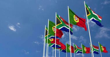 Portogallo e Sud Africa bandiere agitando insieme nel il cielo, senza soluzione di continuità ciclo continuo nel vento, spazio su sinistra lato per design o informazione, 3d interpretazione video