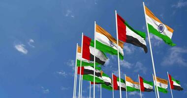 unido árabe emiratos y India bandera ondulación juntos en el cielo, sin costura lazo en viento, espacio en izquierda lado para diseño o información, 3d representación video