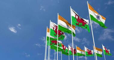 Wales und Indien Flagge winken zusammen im das Himmel, nahtlos Schleife im Wind, Raum auf links Seite zum Design oder Information, 3d Rendern video