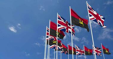 angola och förenad rike flaggor vinka tillsammans i de himmel, sömlös slinga i vind, Plats på vänster sida för design eller information, 3d tolkning video