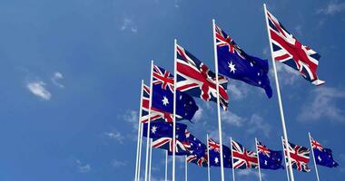 Australie et uni Royaume drapeaux agitant ensemble dans le ciel, sans couture boucle dans vent, espace sur la gauche côté pour conception ou information, 3d le rendu video