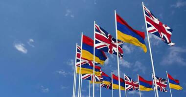 Armenia and United Kingdom Flags Waving Together in the Sky, Seamless Loop in Wind, Space on Left Side for Design or Information, 3D Rendering video