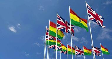 Bolivia and United Kingdom Flags Waving Together in the Sky, Seamless Loop in Wind, Space on Left Side for Design or Information, 3D Rendering video