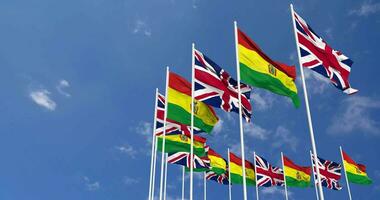 Bolivia and United Kingdom Flags Waving Together in the Sky, Seamless Loop in Wind, Space on Left Side for Design or Information, 3D Rendering video