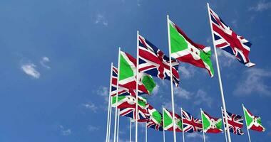 Burundi and United Kingdom Flags Waving Together in the Sky, Seamless Loop in Wind, Space on Left Side for Design or Information, 3D Rendering video