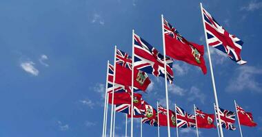 Bermuda and United Kingdom Flags Waving Together in the Sky, Seamless Loop in Wind, Space on Left Side for Design or Information, 3D Rendering video