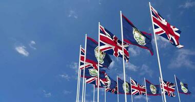 Belize and United Kingdom Flags Waving Together in the Sky, Seamless Loop in Wind, Space on Left Side for Design or Information, 3D Rendering video