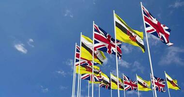 Brunei and United Kingdom Flags Waving Together in the Sky, Seamless Loop in Wind, Space on Left Side for Design or Information, 3D Rendering video