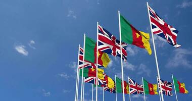 Cameroon and United Kingdom Flags Waving Together in the Sky, Seamless Loop in Wind, Space on Left Side for Design or Information, 3D Rendering video