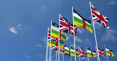 central africain république et uni Royaume drapeaux agitant ensemble dans le ciel, sans couture boucle dans vent, espace sur la gauche côté pour conception ou information, 3d le rendu video