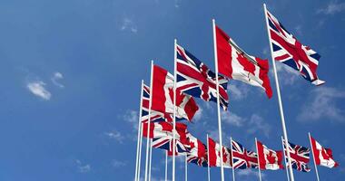 Canada and United Kingdom Flags Waving Together in the Sky, Seamless Loop in Wind, Space on Left Side for Design or Information, 3D Rendering video