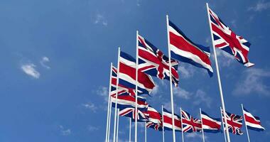 Costa Rica and United Kingdom Flags Waving Together in the Sky, Seamless Loop in Wind, Space on Left Side for Design or Information, 3D Rendering video