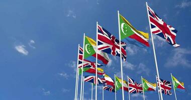 Comores e Unidos reino bandeiras acenando juntos dentro a céu, desatado ciclo dentro vento, espaço em esquerda lado para Projeto ou Informação, 3d Renderização video