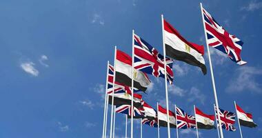 Egypt and United Kingdom Flags Waving Together in the Sky, Seamless Loop in Wind, Space on Left Side for Design or Information, 3D Rendering video