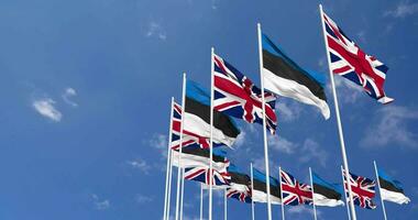 Estônia e Unidos reino bandeiras acenando juntos dentro a céu, desatado ciclo dentro vento, espaço em esquerda lado para Projeto ou Informação, 3d Renderização video