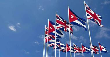 Cuba et uni Royaume drapeaux agitant ensemble dans le ciel, sans couture boucle dans vent, espace sur la gauche côté pour conception ou information, 3d le rendu video