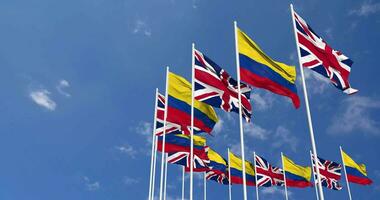 Colombia and United Kingdom Flags Waving Together in the Sky, Seamless Loop in Wind, Space on Left Side for Design or Information, 3D Rendering video