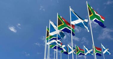 Scozia e Sud Africa bandiere agitando insieme nel il cielo, senza soluzione di continuità ciclo continuo nel vento, spazio su sinistra lato per design o informazione, 3d interpretazione video