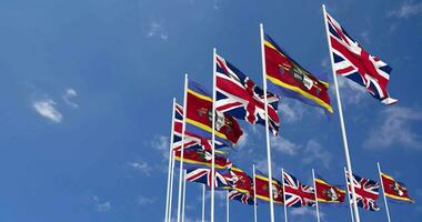 eswatini en Verenigde koninkrijk vlaggen golvend samen in de lucht, naadloos lus in wind, ruimte Aan links kant voor ontwerp of informatie, 3d renderen video