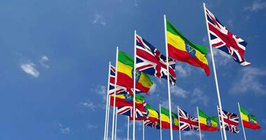 Etiopía y unido Reino banderas ondulación juntos en el cielo, sin costura lazo en viento, espacio en izquierda lado para diseño o información, 3d representación video