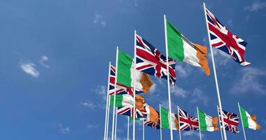 Ireland and United Kingdom Flags Waving Together in the Sky, Seamless Loop in Wind, Space on Left Side for Design or Information, 3D Rendering video