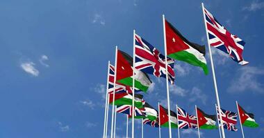 Jordan and United Kingdom Flags Waving Together in the Sky, Seamless Loop in Wind, Space on Left Side for Design or Information, 3D Rendering video