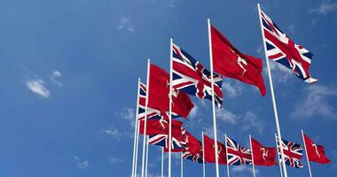 île de homme et uni Royaume drapeaux agitant ensemble dans le ciel, sans couture boucle dans vent, espace sur la gauche côté pour conception ou information, 3d le rendu video