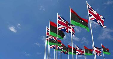 Libya and United Kingdom Flags Waving Together in the Sky, Seamless Loop in Wind, Space on Left Side for Design or Information, 3D Rendering video