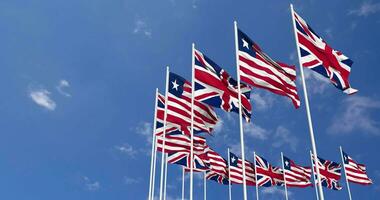 Liberia und vereinigt Königreich Flaggen winken zusammen im das Himmel, nahtlos Schleife im Wind, Raum auf links Seite zum Design oder Information, 3d Rendern video