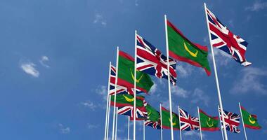 Mauritania y unido Reino banderas ondulación juntos en el cielo, sin costura lazo en viento, espacio en izquierda lado para diseño o información, 3d representación video