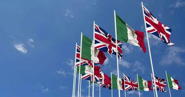 Mexico and United Kingdom Flags Waving Together in the Sky, Seamless Loop in Wind, Space on Left Side for Design or Information, 3D Rendering video