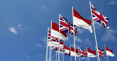 Monaco and United Kingdom Flags Waving Together in the Sky, Seamless Loop in Wind, Space on Left Side for Design or Information, 3D Rendering video