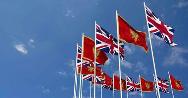 Montenegro and United Kingdom Flags Waving Together in the Sky, Seamless Loop in Wind, Space on Left Side for Design or Information, 3D Rendering video