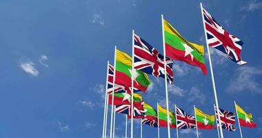 Myanmar, Burma and United Kingdom Flags Waving Together in the Sky, Seamless Loop in Wind, Space on Left Side for Design or Information, 3D Rendering video