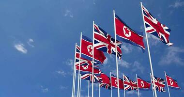 North Korea and United Kingdom Flags Waving Together in the Sky, Seamless Loop in Wind, Space on Left Side for Design or Information, 3D Rendering video