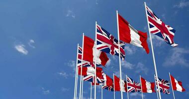 Peru and United Kingdom Flags Waving Together in the Sky, Seamless Loop in Wind, Space on Left Side for Design or Information, 3D Rendering video