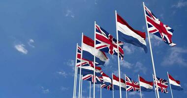 Netherlands and United Kingdom Flags Waving Together in the Sky, Seamless Loop in Wind, Space on Left Side for Design or Information, 3D Rendering video