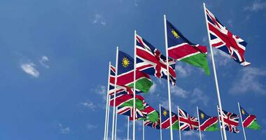 Namibia and United Kingdom Flags Waving Together in the Sky, Seamless Loop in Wind, Space on Left Side for Design or Information, 3D Rendering video