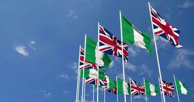 Nigeria and United Kingdom Flags Waving Together in the Sky, Seamless Loop in Wind, Space on Left Side for Design or Information, 3D Rendering video