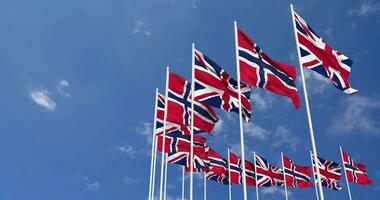 Norvège et uni Royaume drapeaux agitant ensemble dans le ciel, sans couture boucle dans vent, espace sur la gauche côté pour conception ou information, 3d le rendu video