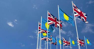 Palau and United Kingdom Flags Waving Together in the Sky, Seamless Loop in Wind, Space on Left Side for Design or Information, 3D Rendering video