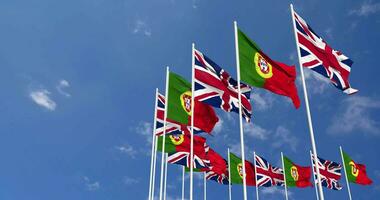 Portugal and United Kingdom Flags Waving Together in the Sky, Seamless Loop in Wind, Space on Left Side for Design or Information, 3D Rendering video