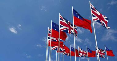 Samoa en Verenigde koninkrijk vlaggen golvend samen in de lucht, naadloos lus in wind, ruimte Aan links kant voor ontwerp of informatie, 3d renderen video