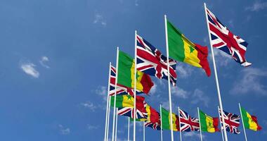 Senegal and United Kingdom Flags Waving Together in the Sky, Seamless Loop in Wind, Space on Left Side for Design or Information, 3D Rendering video