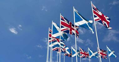 Scozia e unito regno bandiere agitando insieme nel il cielo, senza soluzione di continuità ciclo continuo nel vento, spazio su sinistra lato per design o informazione, 3d interpretazione video