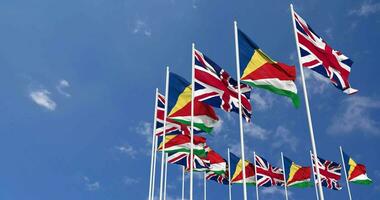 Seychellen und vereinigt Königreich Flaggen winken zusammen im das Himmel, nahtlos Schleife im Wind, Raum auf links Seite zum Design oder Information, 3d Rendern video