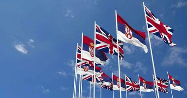 Serbia and United Kingdom Flags Waving Together in the Sky, Seamless Loop in Wind, Space on Left Side for Design or Information, 3D Rendering video