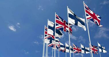 Finland and United Kingdom Flags Waving Together in the Sky, Seamless Loop in Wind, Space on Left Side for Design or Information, 3D Rendering video