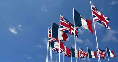 France et uni Royaume drapeaux agitant ensemble dans le ciel, sans couture boucle dans vent, espace sur la gauche côté pour conception ou information, 3d le rendu video