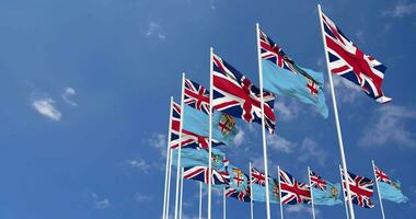 Fiji and United Kingdom Flags Waving Together in the Sky, Seamless Loop in Wind, Space on Left Side for Design or Information, 3D Rendering video